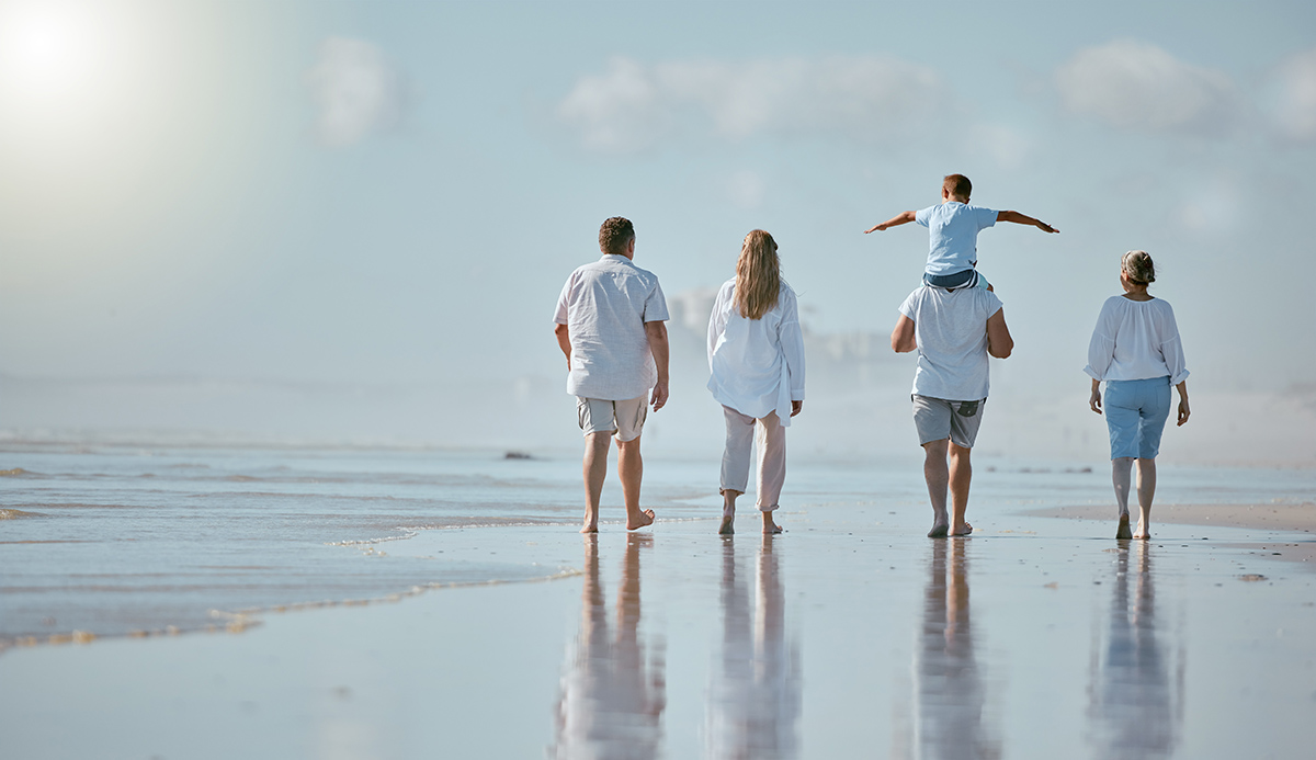 Family, beach and men with women and child from back with blue sky on outdoor summer vacation. Happ.